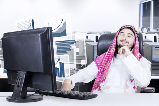 Arabian man looking at financial graph