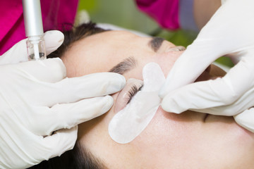Woman on the procedure for eyelash extensions, eyelashes lamination