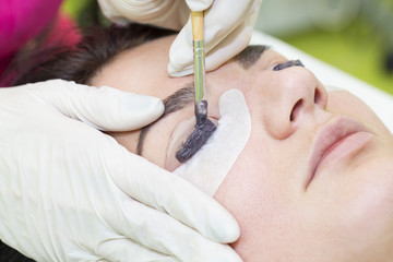 Woman on the procedure for eyelash extensions, eyelashes lamination