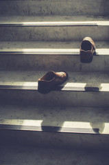 A pair of man's shoes on stairs which reminds us of American proverb: 