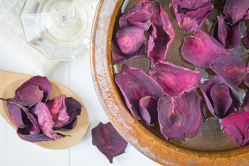 Spa background with beautiful rose petals and a clay bowl.