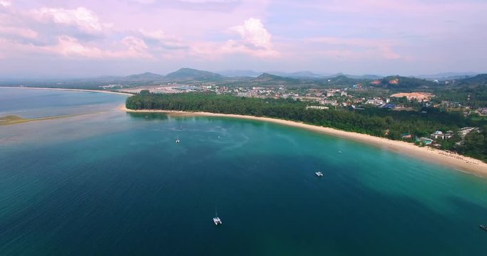 Aerial footage. Flying close over tropical sandy beach and yachts. Thailand. Phuket. Layan beach. 4K