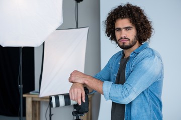 Happy male photographer standing in studio