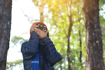 Asian women holding a camera shooting in nature and relax time on holiday.concept travel color of vintage tone