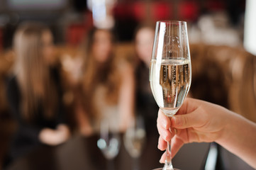 glass of champagne on the background of friends at a party