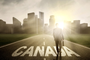 Businessman with word of Canada at sunrise