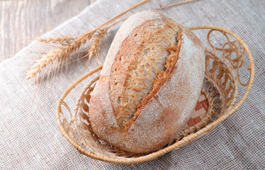 loaf of bread on a wicker saucer, closeup top view