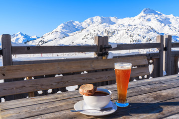 Glass of cold beer and hot soup on wooden table of mountain hut in Obertauern ski area, Austria