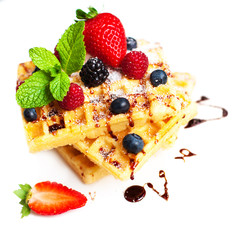 Belgian waffles with fresh berries isolated on white background.
