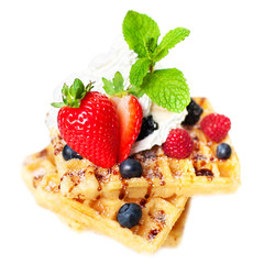 Belgian waffles with fresh berries isolated on white background.