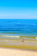 Man standing in water on beach in Jastrzebia Gora, Baltic Sea, Poland