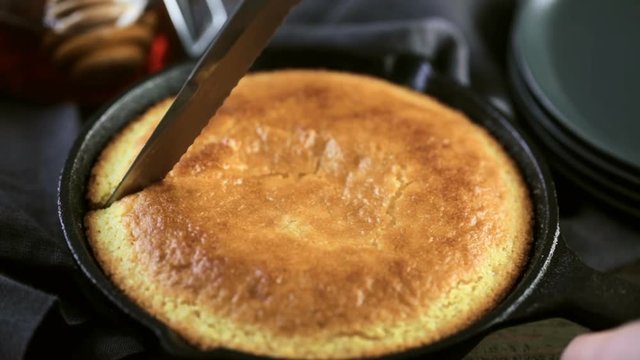 Slice of sweet cornbread with honey on the plate