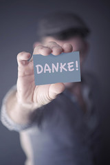 man showing card with german word for Thank You