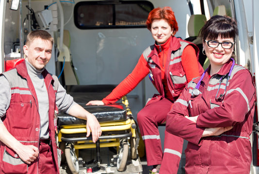 Paramedic professional female with coworker colleague near ambulance machine on background
