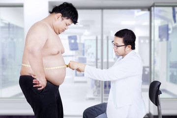 Doctor measuring overweight stomach