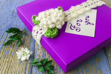 gift box with note on wooden background