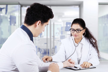 Fototapeta premium Indian doctor checking male patient