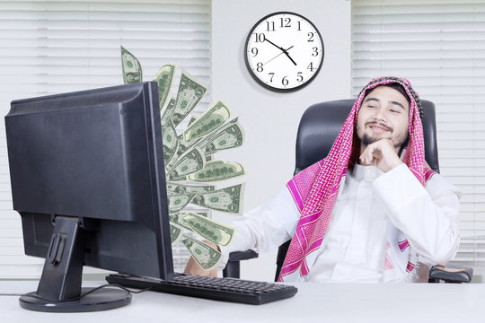 Muslim businessman looking at money