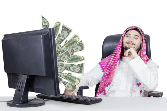 Muslim businessman looking money on monitor
