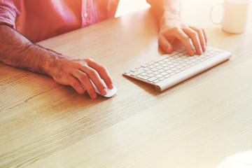 hands working with computer with wireless keyboard and mouse