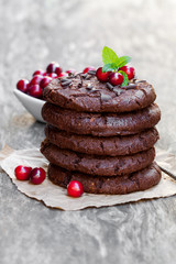Stack  of dark chocolate cookies with cranberry on wooden backgr