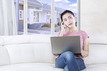 Naklejka premium Woman uses laptop and looking up