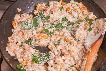 Cooking a pasta cream sauce with bacon, mushrooms, walnuts, spinach