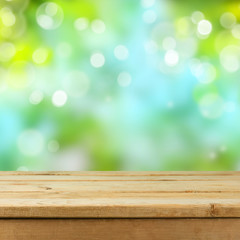 Empty wooden deck table over blurred bokeh nature background for product montage display