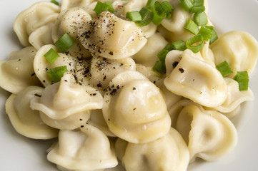 Russian dumplings in a white plate on a black background