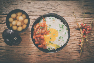 Rice with fried egg and tomato sauce on table vintage wooden sur