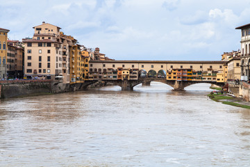 Fototapeta na wymiar dirty water of Arno and Ponte Vecchio in autumn