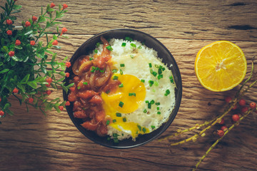 Rice with fried egg and tomato sauce on table vintage wooden sur