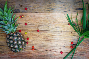 Pineapple, raw coffee beans and grass. on wooden rustic backgrou