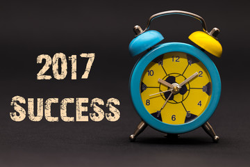 2017 Success written with alarm clock on black paper background