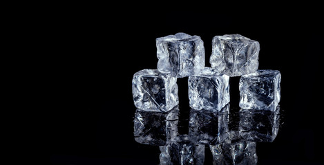 five ice cubes on black background
