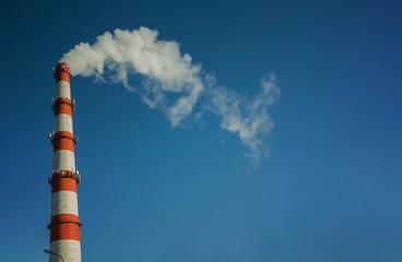 Smoking chimney against the blue sky