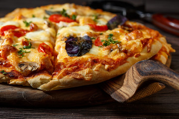 Homemade pizza on a rustic table. Wooden pizza server.