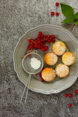 Muffins with red currants on a wooden background. View from above.