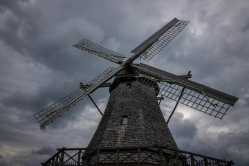 The old windmill in a village against sky