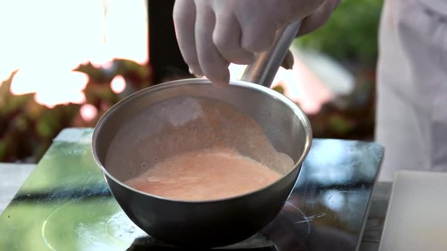 Chef cooks sauce. Hand adding salt into saucepan. Secrets of culinary art.