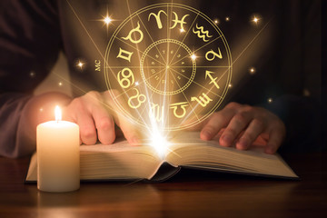 man reading astrology book - obrazy, fototapety, plakaty
