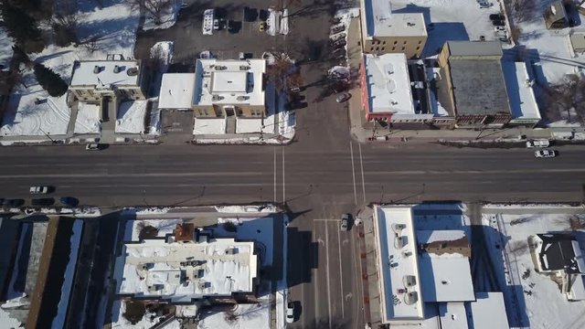 Aerial Ephraim Utah rural town main street traffic business. Winter storm blizzard snow. Rural farm community. Hard seasonal weather. Hazard to driving. Surveillance spy. Drone flight.