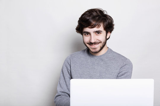 Emotions, human, modern technologies and lifestyle concept. Happy attractive young bearded guy enjoying free wireless connection, browsing internet, using his laptop computer looking with excitement
