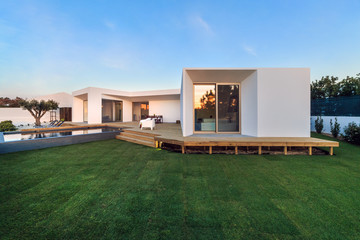 Modern house with garden swimming pool and wooden deck