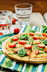 Cauliflower pizza crust with tomato and spinach