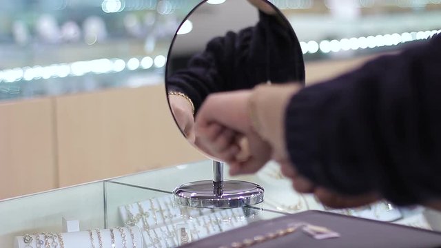 Jewelry store: Young man tries on expensive bracelet. Close up