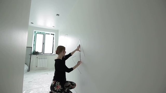 The artist draws a geometrical figure on the wall