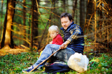 Father and his little son during the hiking activities in forest