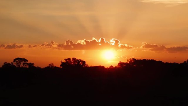 Golden sunset light rays through clouds silver lining