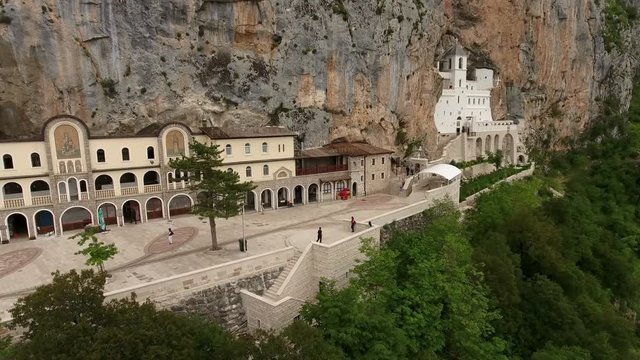 Camera review of upper Serbian Orthodox monastery of Ostrog with walking visitors. Aerial view. The Monastery of Ostrog is monastery of Serbian Orthodox Church, Montenegro
